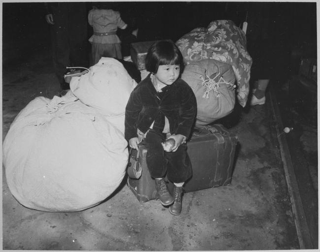 Bimba nippo-americana (nisei) in attesa di essere internata con la sua famiglia, USA 1942