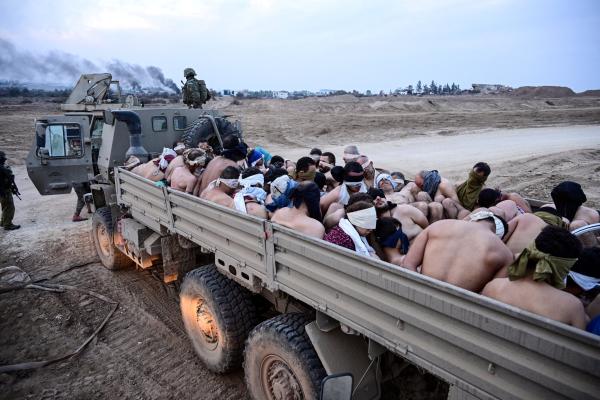  Israeli soldiers stand by a truck packed with shirtless Palestinian detainees in Gaza in December |credit: Reuters