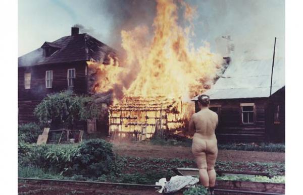 Vancouver, 1962. Una Freedomite assiste, nuda, al rogo dal lei stessa appiccato alla sua proprietà