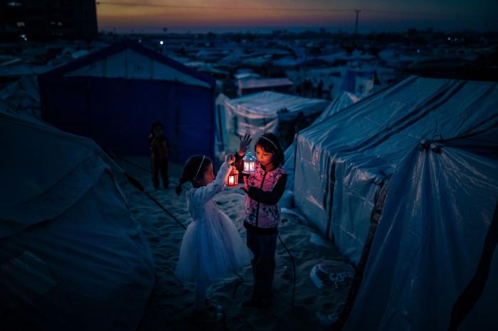 Bambini palestinesi rifugiati a Rafah, nella Striscia di Gaza, decorano le loro tende con lanterne il 29 febbraio in preparazione al mese sacro musulmano del Ramadan.