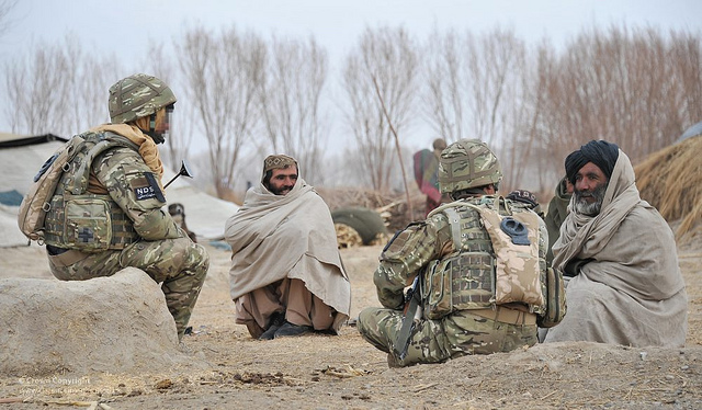 British soldier talking to Afghan civilians with an interpreter during a patrol