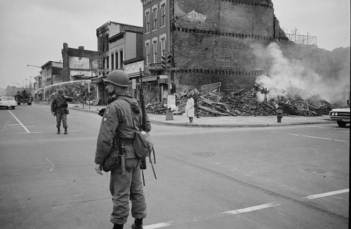 Washington D.C. 1968: un soldato di guardia davanti ad un edificio distrutto in seguito ai disordini seguiti all'assassinio di MLK