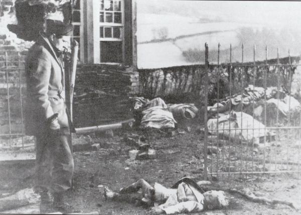 Il corrispondente di guerra Jean Marin accanto ai ‎corpi dei civili massacrati a Stavelot, fine dicembre 1944‎