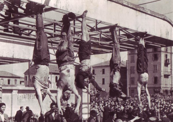 Milano, Piazzale Loreto, 29 aprile 1945. Esposizione dei corpi di Mussolini e della Petacci insieme a quelli di altri tre gerarchi fascisti, dopo la loro fucilazione da parte dei partigiani.