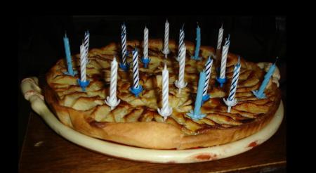 On apporte à table une tarte aux pommes  <br />
 Avec vingt bougies 