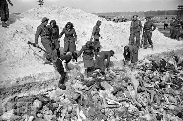 Bergen-Belsen, aprile 1945. Guardie tedesche del campo, sotto il controllo degli inglesi, gettano corpi di prigionieri in una fossa comune (La misura si rese necessaria a causa di una devastante epidemia di tifo in corso).