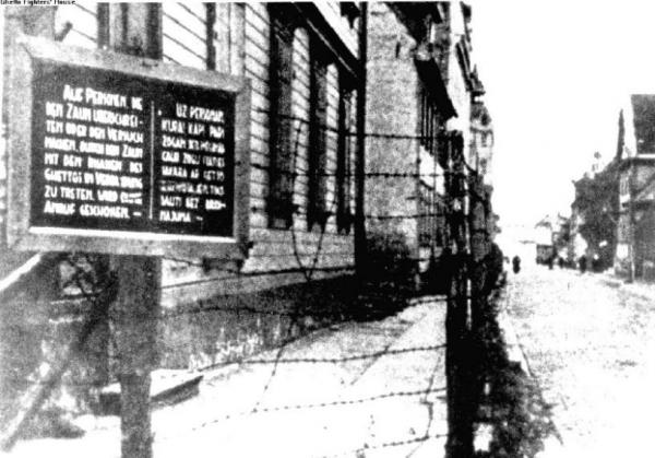 Ghetto di Riga. Un cartello, in tedesco e in lettone, avverte che le guardie spareranno contro chiunque tenterà di superare il recinto o di contattare gli abitanti del ghetto.