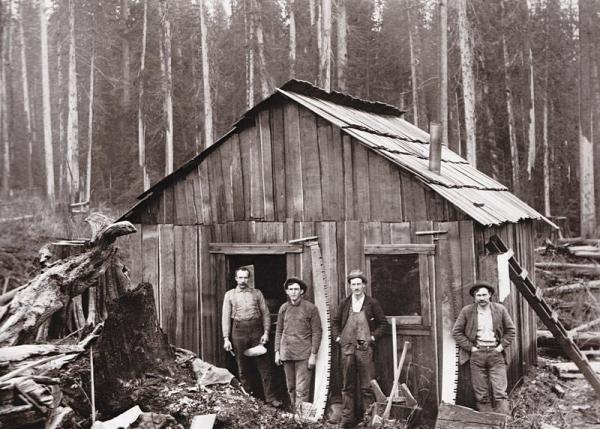Loggers posing in front of their cabin