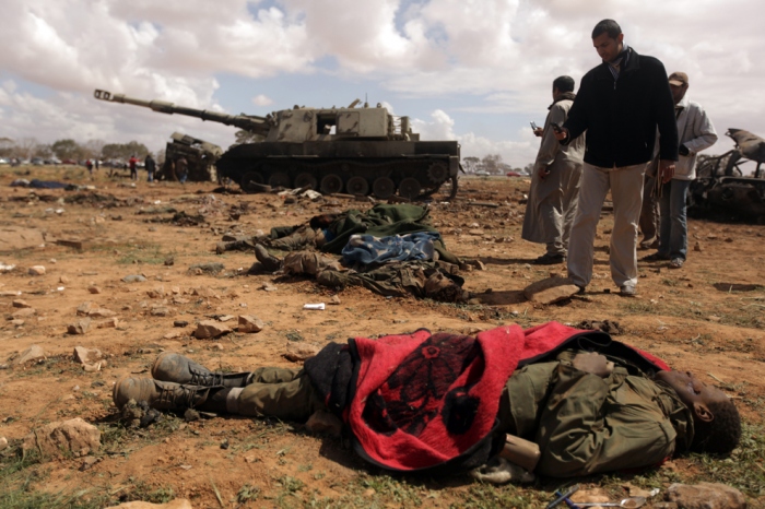 Curious Libyan onlookers take pictures of dead African teenagers, members of Muammar Qaddafi's forces hit by airstrikes by French warplanes in al-Wayfiyah west of Benghazi, on March 20 in al-Wayfiyah. (Patrick Baz/AFP/Getty Images)