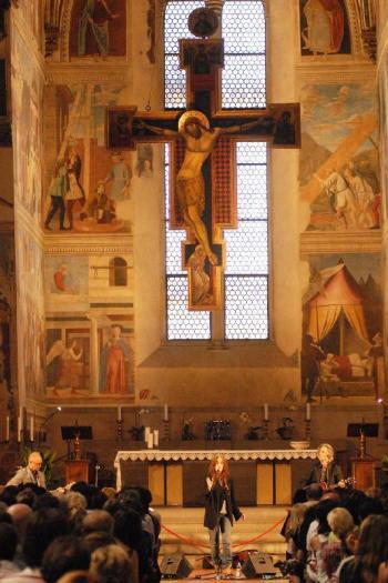 Patti Smith sotto gli affreschi di Piero della Francesca nella Basilica di San Francesco ad Arezzo