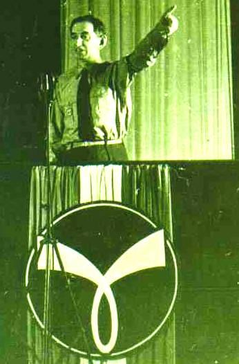 Philippe Henriot, dirigente della Milice française e ministro della propaganda dal 1944, parla da un palco sormontato dalla “croix gammée”, simbolo delle SS francesi.