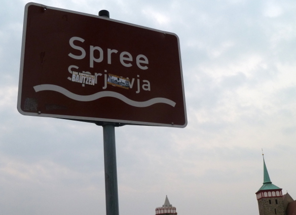Bautzen. Il cartello stradale bilingue che indica il fiume Sprea (toponimo di origine soraba) con la dicitura in Alto Sorabo (Sprjewja) ricoperta di adesivi nazionalisti / razzisti / calcistici tedeschi.