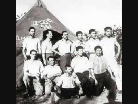 1948: Mikis Theodorakis a Makronissos, assieme ad altri prigionieri. È l'ultimo inginocchiato a destra.
