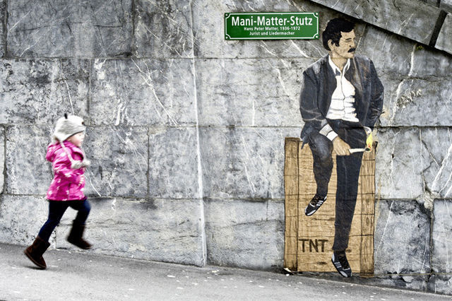 Berna: L'attacco della Mani-Matter-Stutz (Bastione Mani Matter), la breve scalinata che porta al Terrazzo Federale. Un artista di strada vi ha dipinto un'immagine di Mani Matter seduto su una cassa di dinamite e con in mano una torcia accesa.